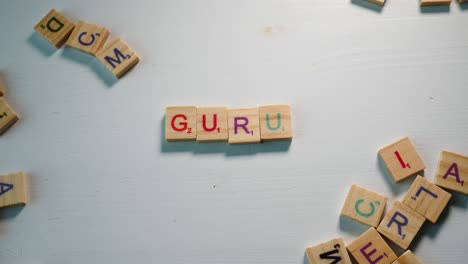 una mesa con letras de madera dispersas y un gurú ortográfico