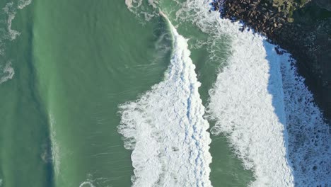 waves crash on rocky nazare coast, aerial view from miradouro do salgado