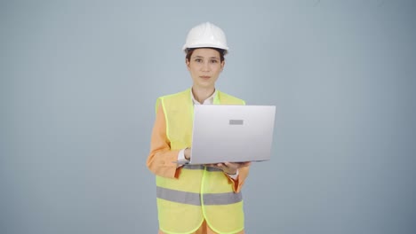 engineer holding laptop laughing at camera.