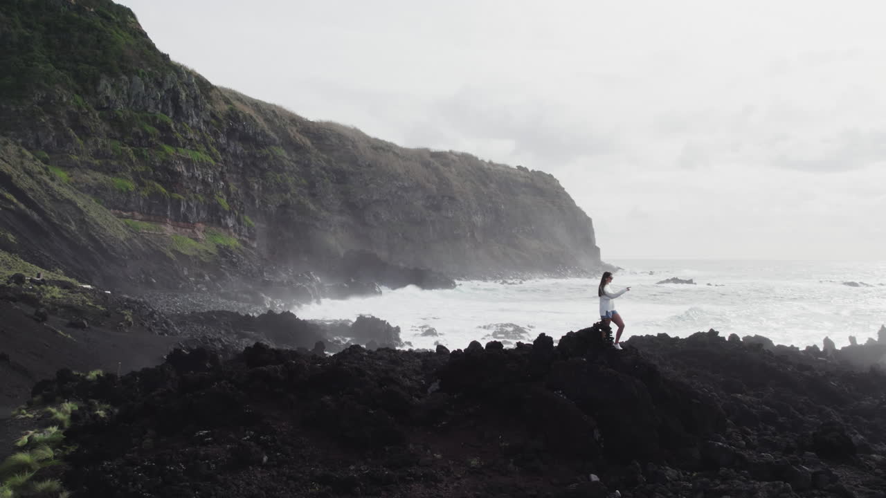 Girl tourist at Ponta da Ferraria, S&atilde;o Miguel Azores, overlooking ocean and cliffs