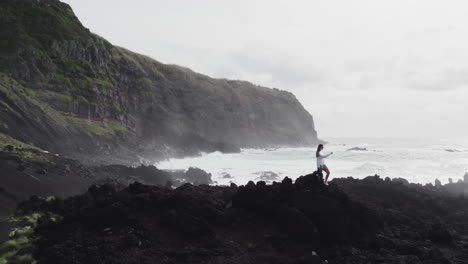 chica turista en ponta da ferraria, são miguel azores, con vistas al océano y los acantilados