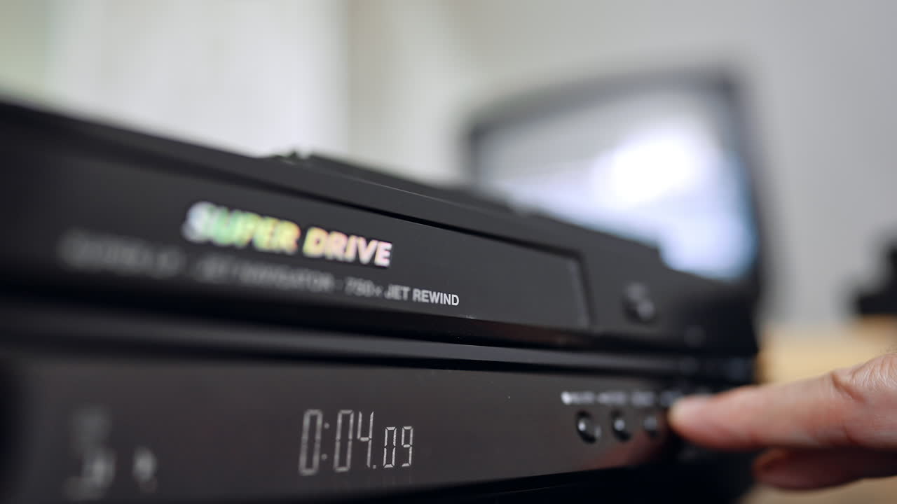 Front panel of the DVD player. Hand presses the button on the device. Close up