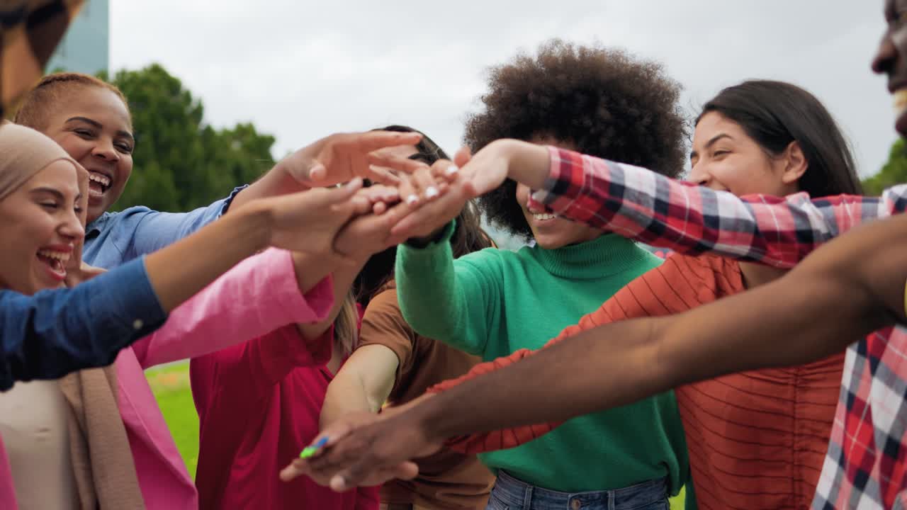 joven grupo multiétnico de personas que se juntan las manos al aire libre - trabajo en equipo concepto de diversidad y unidad
