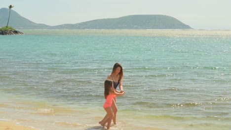 mother and daughter having fun at the beach 4k