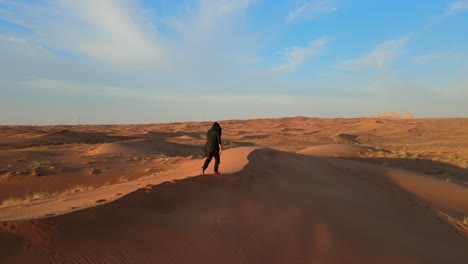 Vista-De-Drones:-Un-Hombre-Camina-Solo-En-El-Desierto-árabe-De-Los-Emiratos-árabes-Unidos,-Video-Del-Paisaje-Del-Desierto-Del-Golfo,-Desierto-De-Los-Emiratos-árabes-Unidos