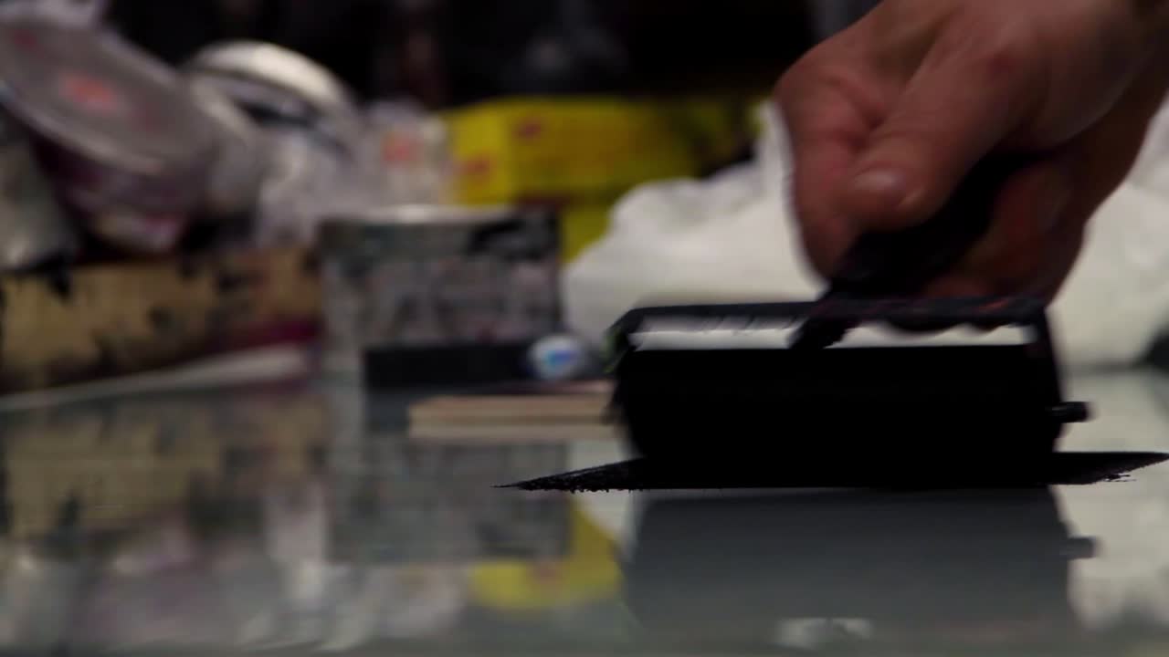 Artist spreads ink for a woodblock print.