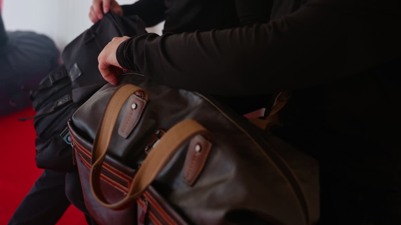 Policemen holding leather sports bag inside martial arts gym with red mat, preparing for training, symbolizing strength, readiness, discipline, determination,professional physical preparation