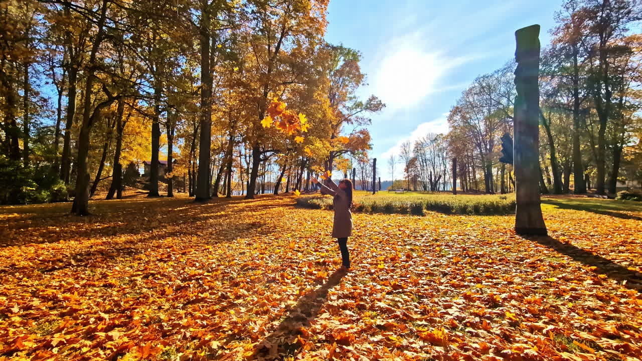 Child playing in autumn leaves, Lielvarde, Latvia on a sunny day
