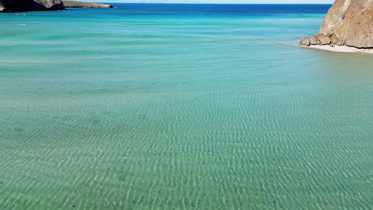 Aerial drone view of the calm turquoise sea and rocky coastline of Baja California, Mexico