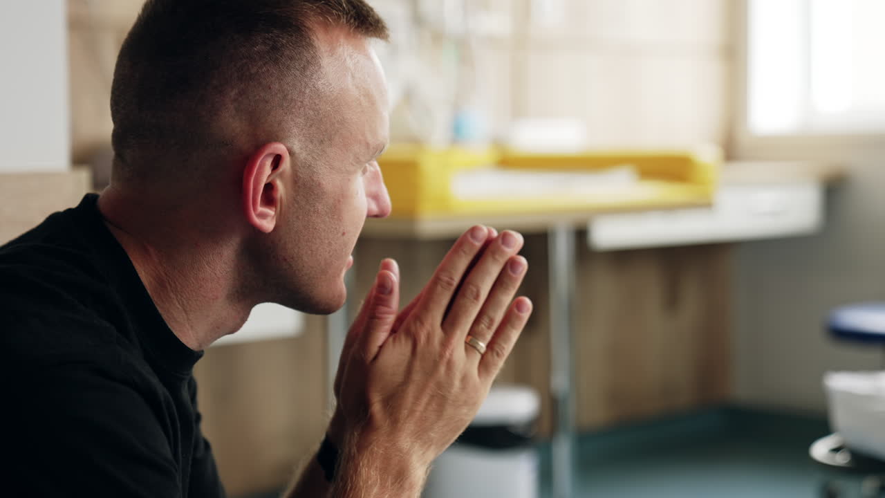 Caucasian man side view portrait. Man talking to his wife lying in the hospital bed at backdrop.