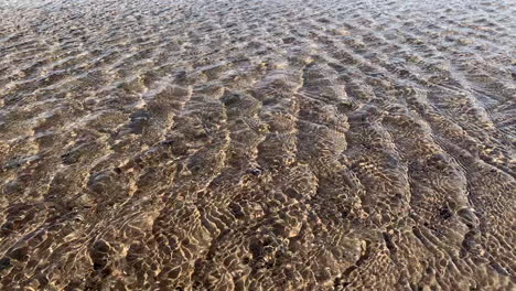 Rápidas-Ondas-De-Agua-Brillando-En-El-Viento-En-Una-Playa-Con-El-Lecho-Del-Río-De-Arena