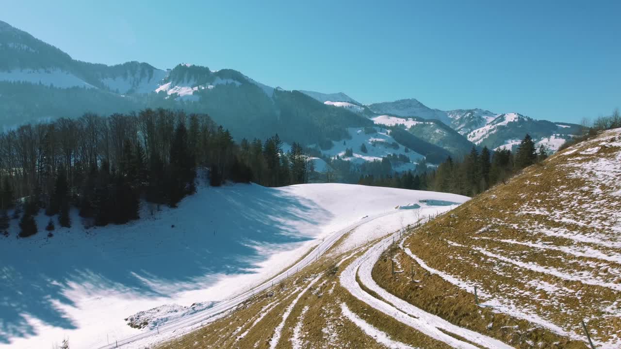 4K UHD aerial drone flight moving above snowy hills and tree tops in the Bavarian Alps in winter in Germany, close to Austria