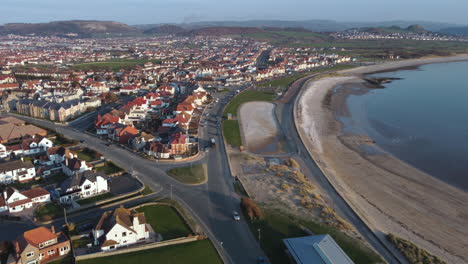 an aerial view of llandudno south beach and shoreline on a sunny evening, flying towards the beach from the great orme, clwyd, north wales, uk