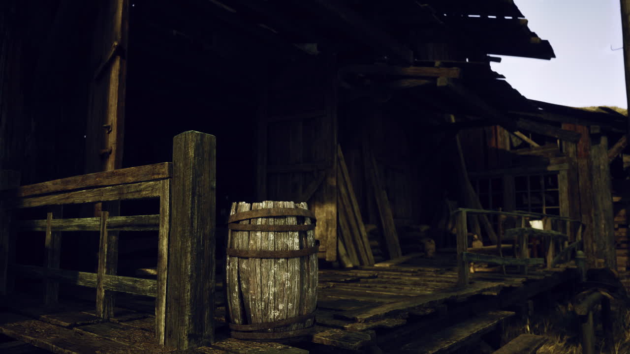 Old wooden building with weathered planks and a barrel at sunset