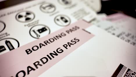close up printed boarding pass over prohibited items list informing passengers about dangerous goods before boarding airplane