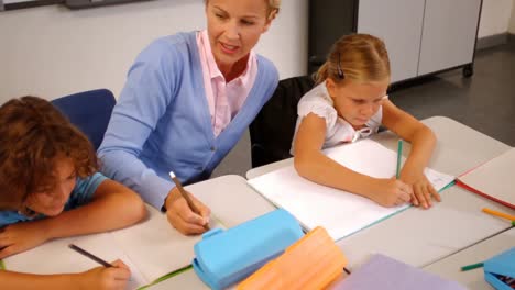 teacher helping kids with their homework in classroom