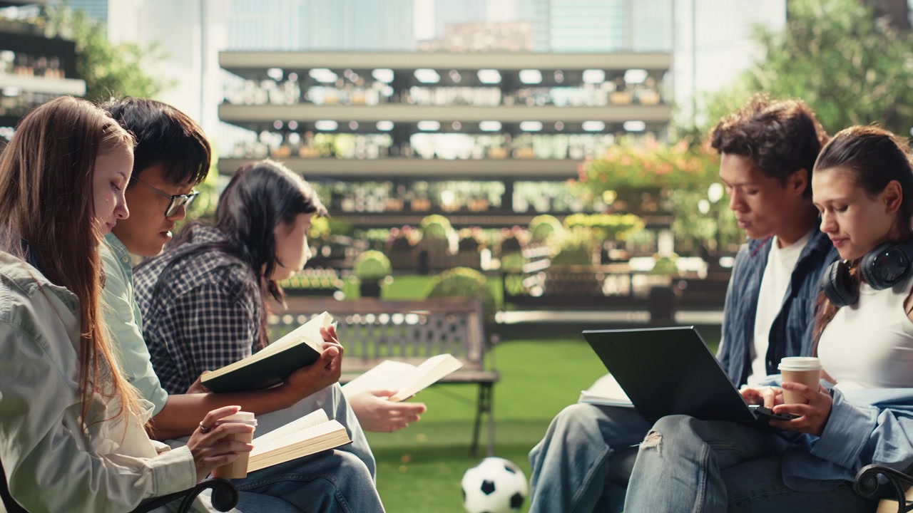 Classmates sitting on campus benches for quiet study with laptop