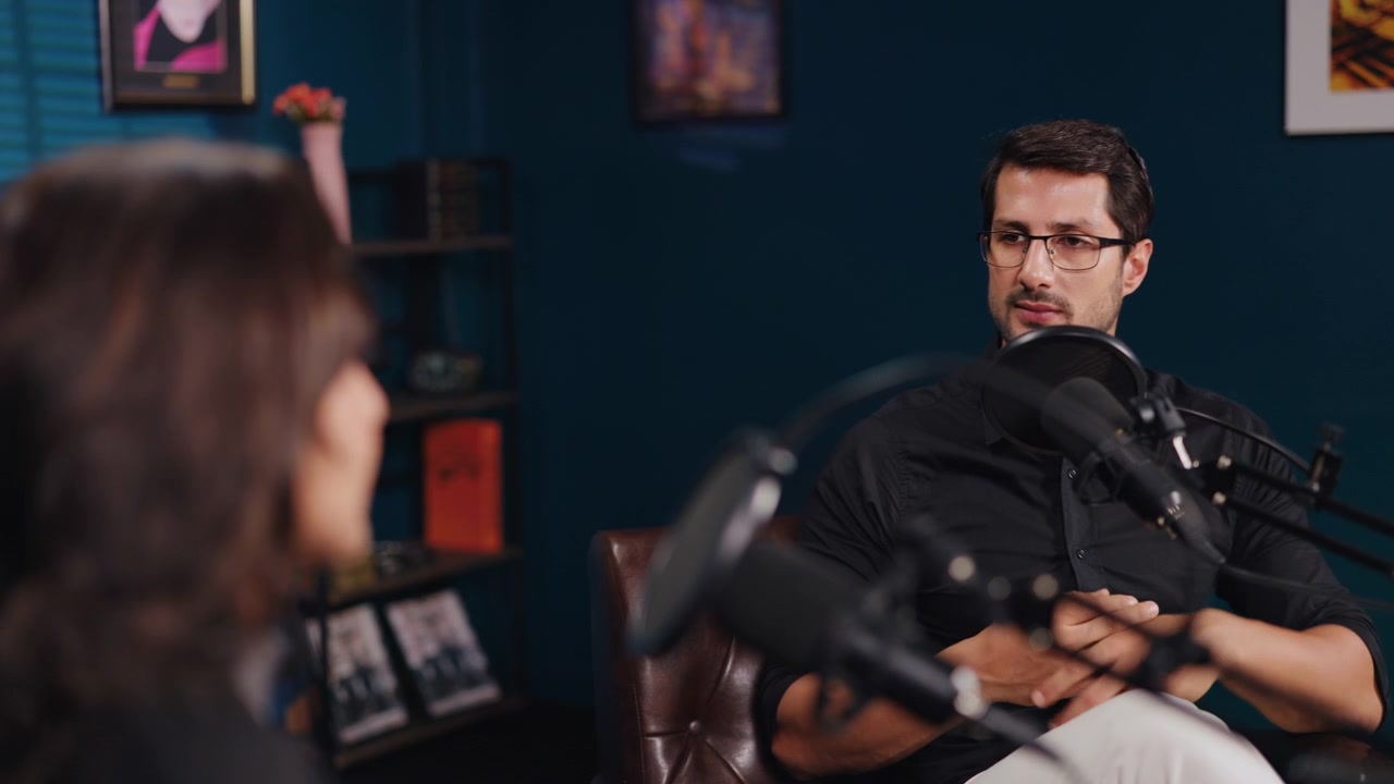 Muž poskytující rozhovor v podcastu ve studiu