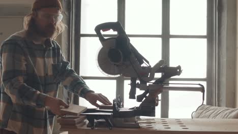 male carpenter using circular saw while working