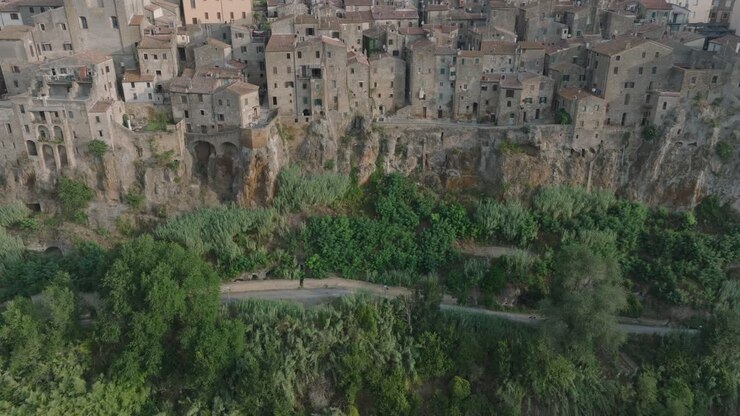 High Angle Aerial Drone view of the hilltop Medieval town of Pitigliano, Tuscany in morning light, with the Valdorcia and old buildings, in 4K