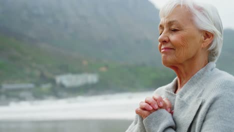 Senior-woman-meditating-on-beach