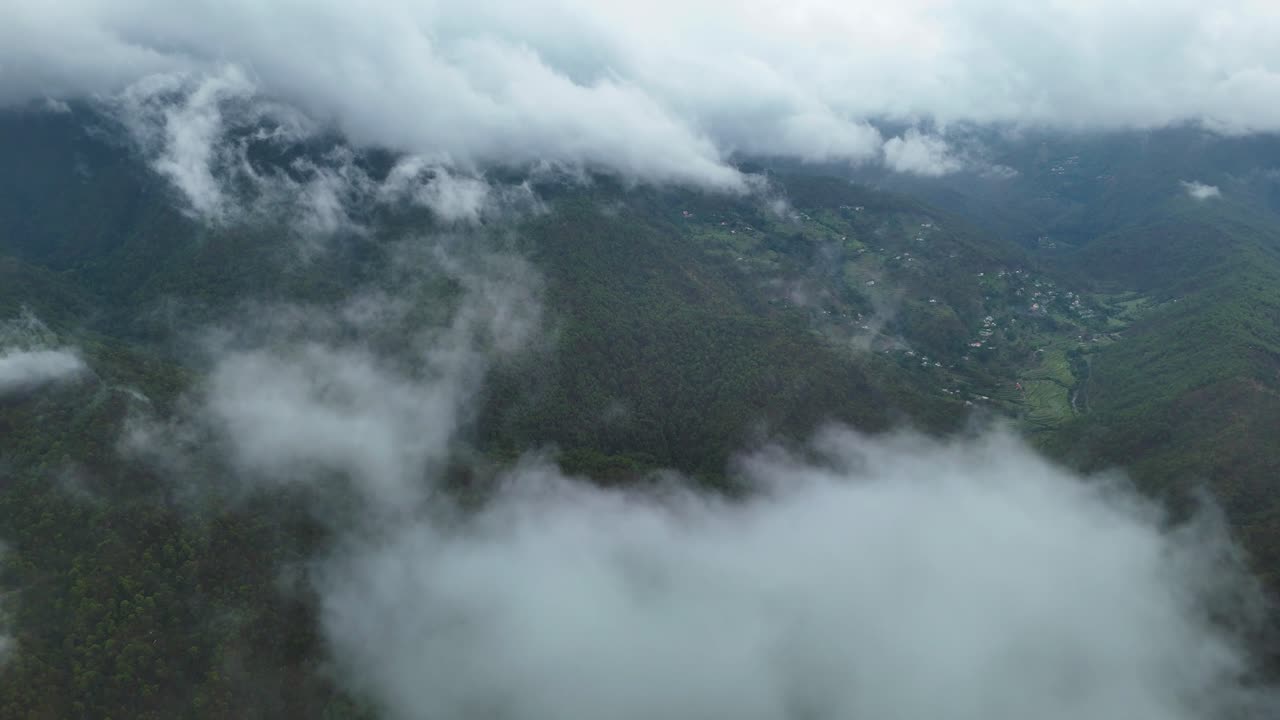 Aerial drone shot of a vibrant morning sky over mist-shrouded mountain forests.