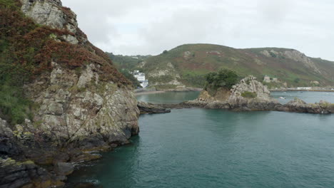 a drone shot flying past rocks along the jersey coastline around bouley bay on the north coast