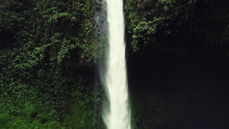 Tilt-down-shot-of-waterfall-pouring-into-pool-in-Costa-Rica-rain-forest