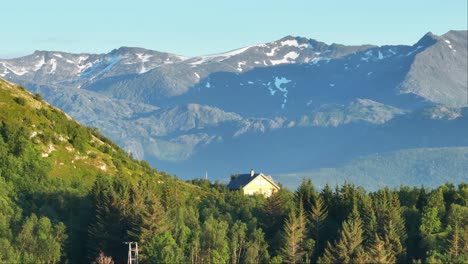 house on hilltop with verdant trees on a sunny day in norway