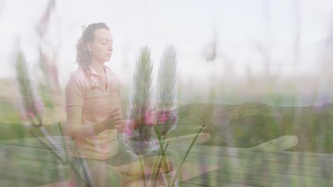 Animation-of-landscape-over-caucasian-woman-practicing-yoga-and-meditating