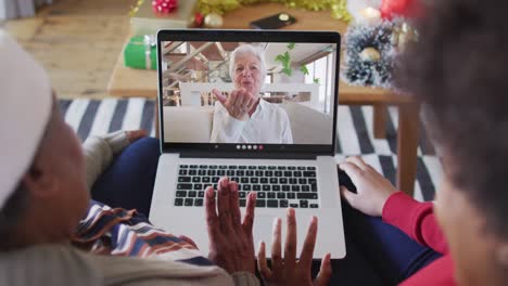 Madre-E-Hija-Afroamericanas-Usando-Una-Computadora-Portátil-Para-Una-Videollamada-Navideña-Con-Una-Mujer-En-La-Pantalla