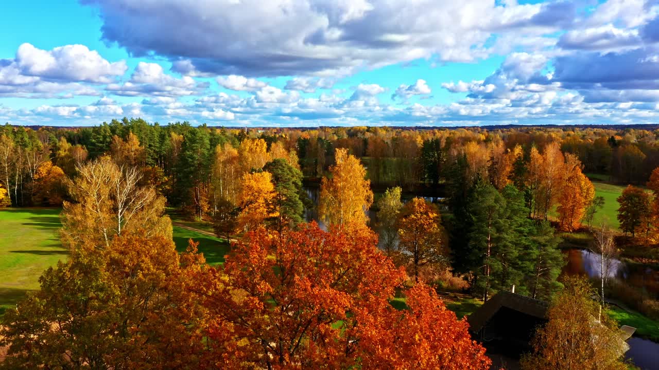 Weitläufige Luftaufnahme von Wald, Park und Flüssen, die sich durch eine farbenfrohe Herbstlandschaft ziehen