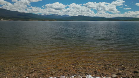 Aerial-cinematic-drone-shoreline-Grand-Lake-Shadow-Mountain-Grandby-Colorado-Rocky-Mountain-National-park-entrance-calm-clear-ripples-beautiful-summer-morning-boating-two-islands-forward-upward-slowly