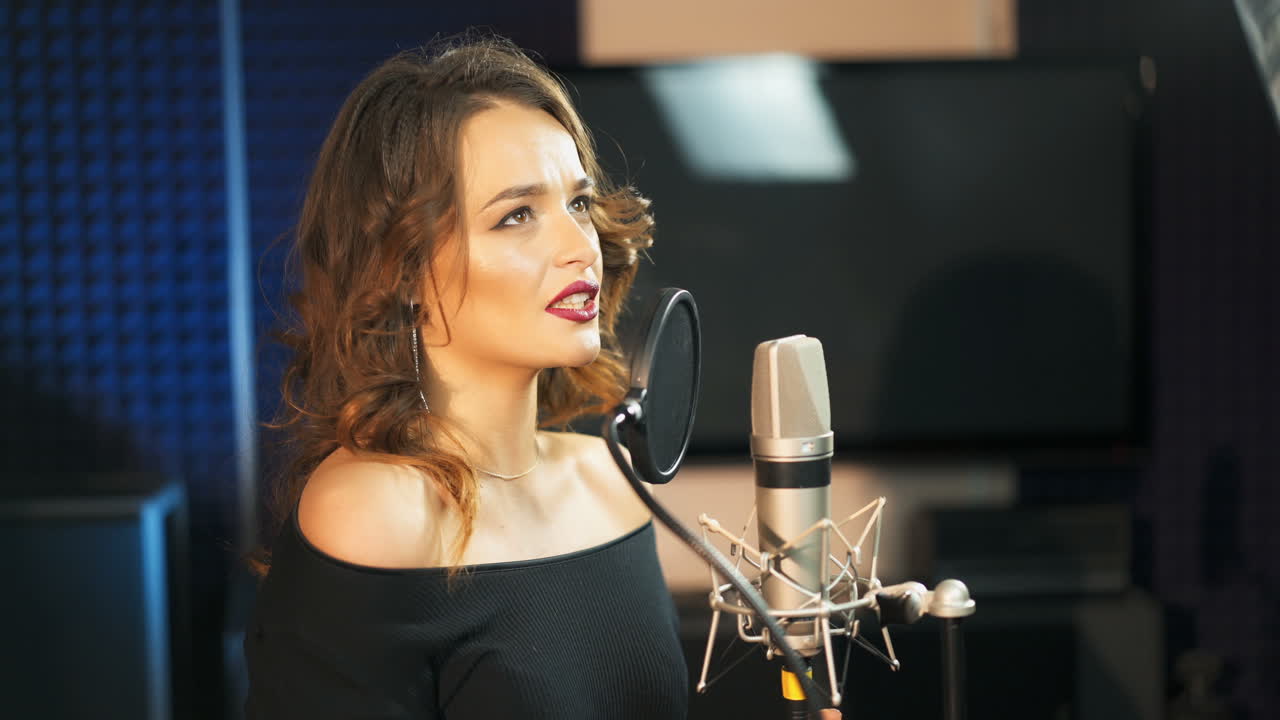 Beautiful sexy young woman singing. Female vocal. Professional recording studio.