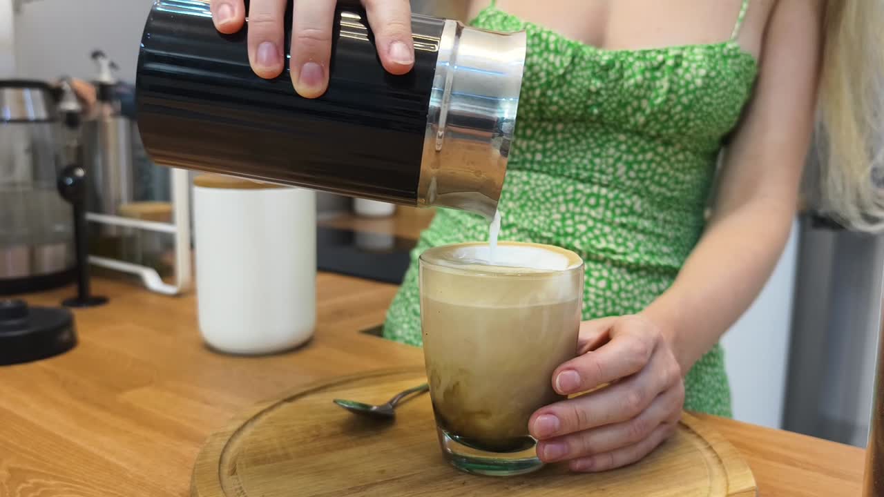 una mujer preparando un capuchino.