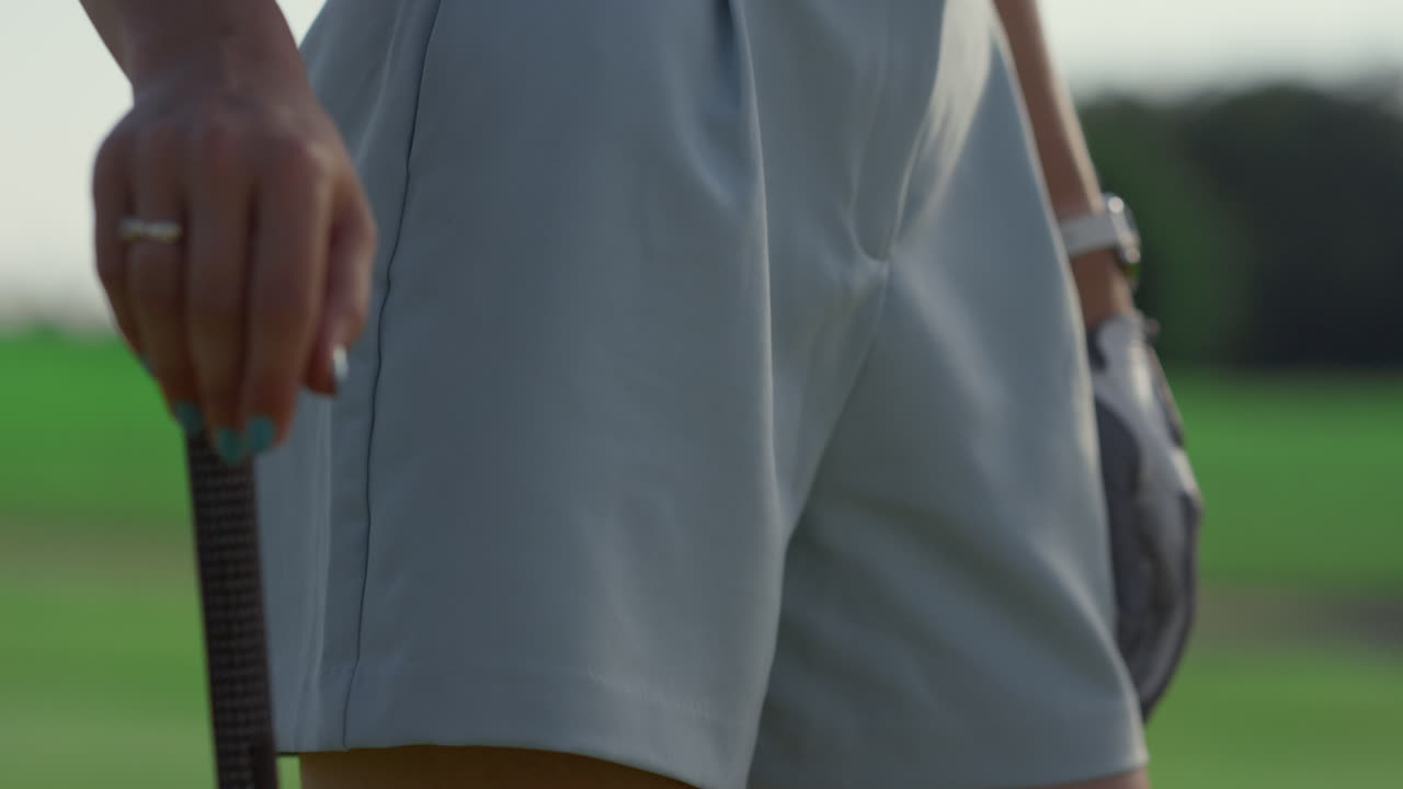 스포츠 여자 는 골프 코스 밖 에 서 있다. 골프 선수 는 유니폼 스포츠 슈트 쇼트 를 입는다