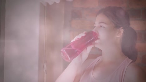 animation of flickering lights over woman drinking water during exercise at home