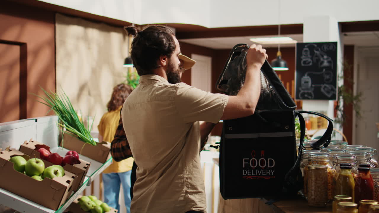 el repartidor recoge el pedido de la tienda biológica.