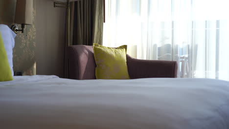 luxury hotel room with green pillows and sunlight