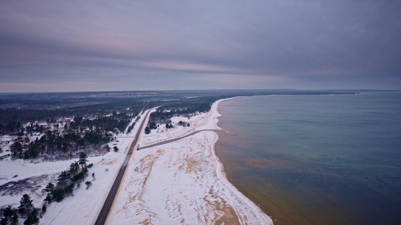 Droneopptak av snødekt landskap i Nord-Michigan med US highway 2 og Lake Superior i bildet