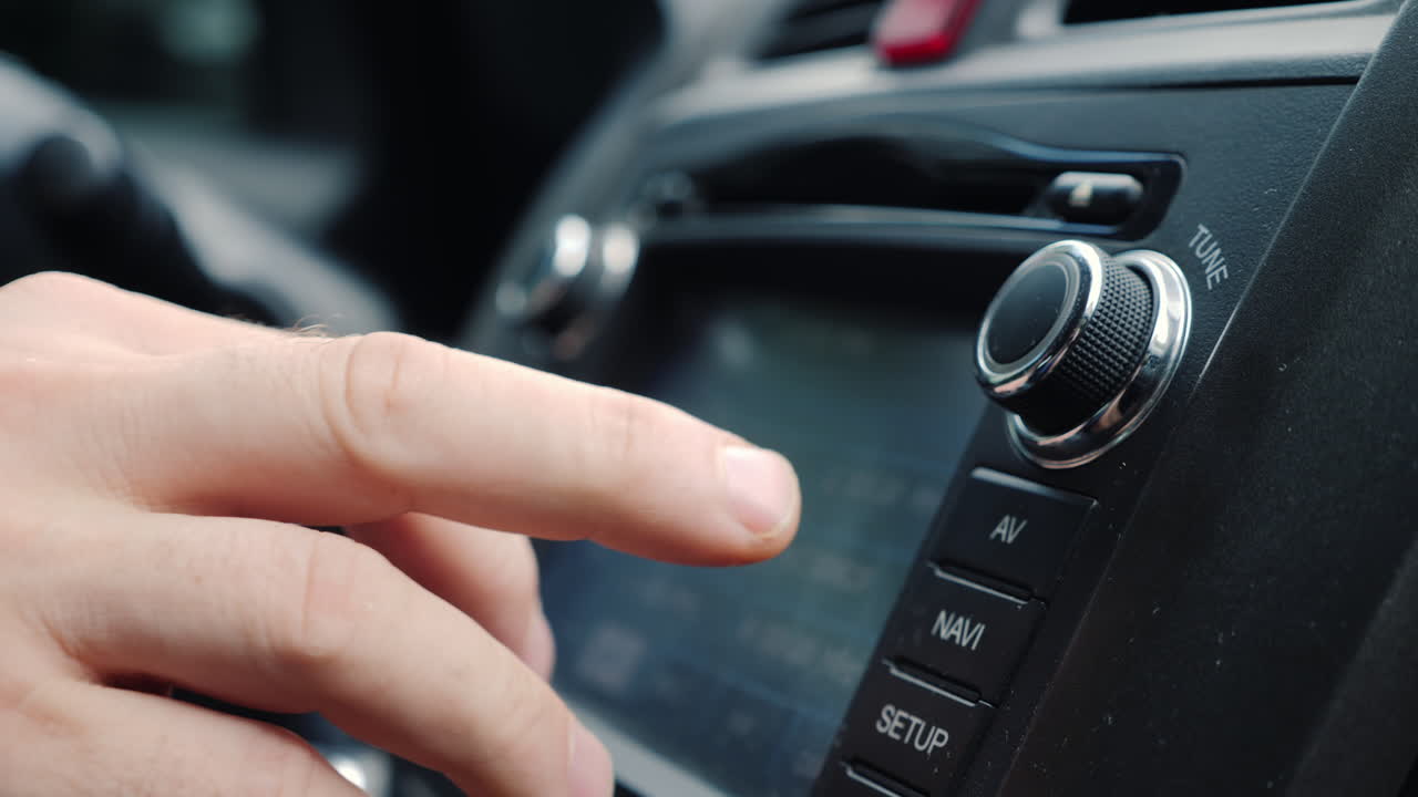 남성 손은 자동차 라디오 클로즈업 샷의 튜닝을 조정합니다.