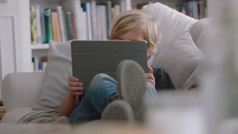 happy-little-boy-using-digital-tablet-computer-playing-game-relaxing-on-sofa-at-home-child-browsing-online-with-mobile-device-technology-anti-social-addiction-concept-4k