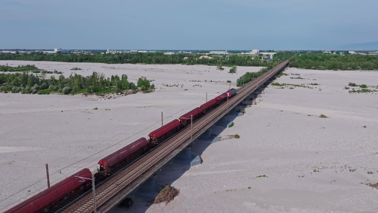 Drone shot of Passing train on the bridge above dry rocky river creek