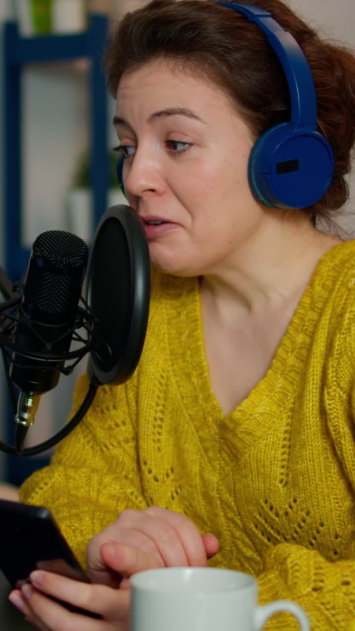 Vertical video: Video blogger reading questions from fans using smartphone