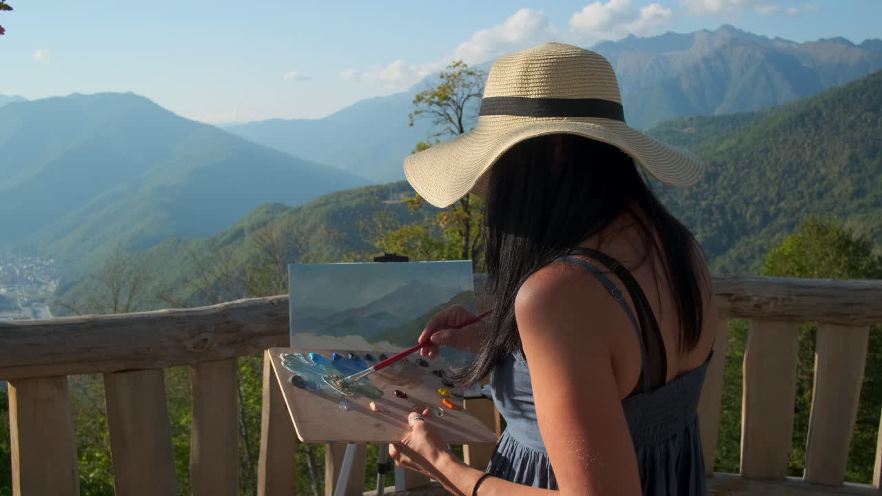 mujer pintando un paisaje panorámico de montaña