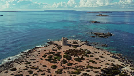 Vista-Aérea-De-La-Torre-De-Ses-Portes-Y-El-Mar-Azul-En-Ibiza,-España.