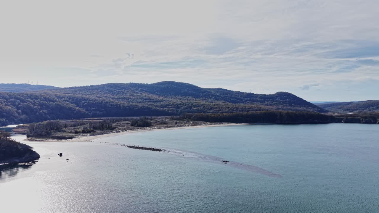 Scenic aerial view of a tranquil bay surrounded by rolling hills