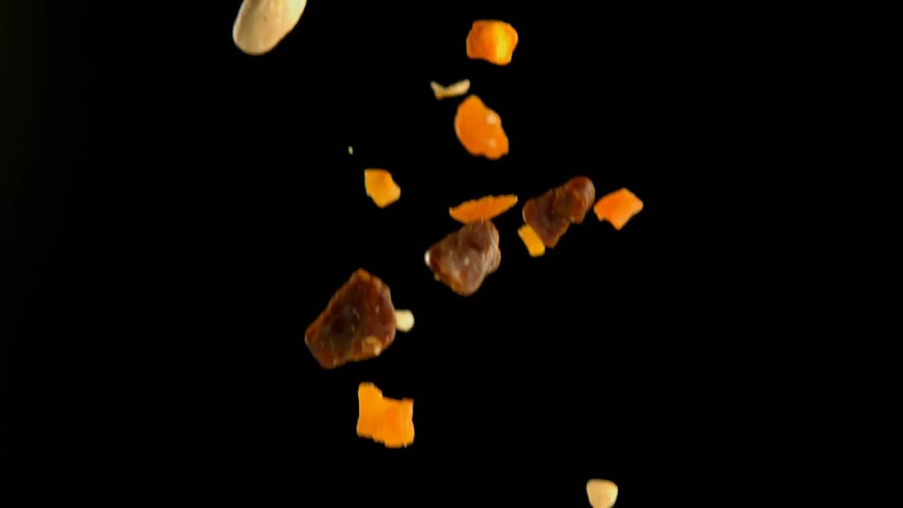 Dry fruits falling against black background 4k