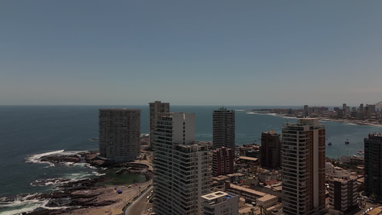 Iquique playa brava chile tarapaca cavancha day beach blue sky city at noon buildings