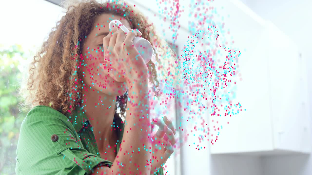Donna che si protende per afferrare una tazza sul bancone, dando il via a particelle rosa e verde acqua che turbinano attorno al busto per uno spot tecnologico.